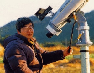 Yuji Hyakutake met zijn verrekijker waarmee hij zijn bereomde komeet ontdekte.