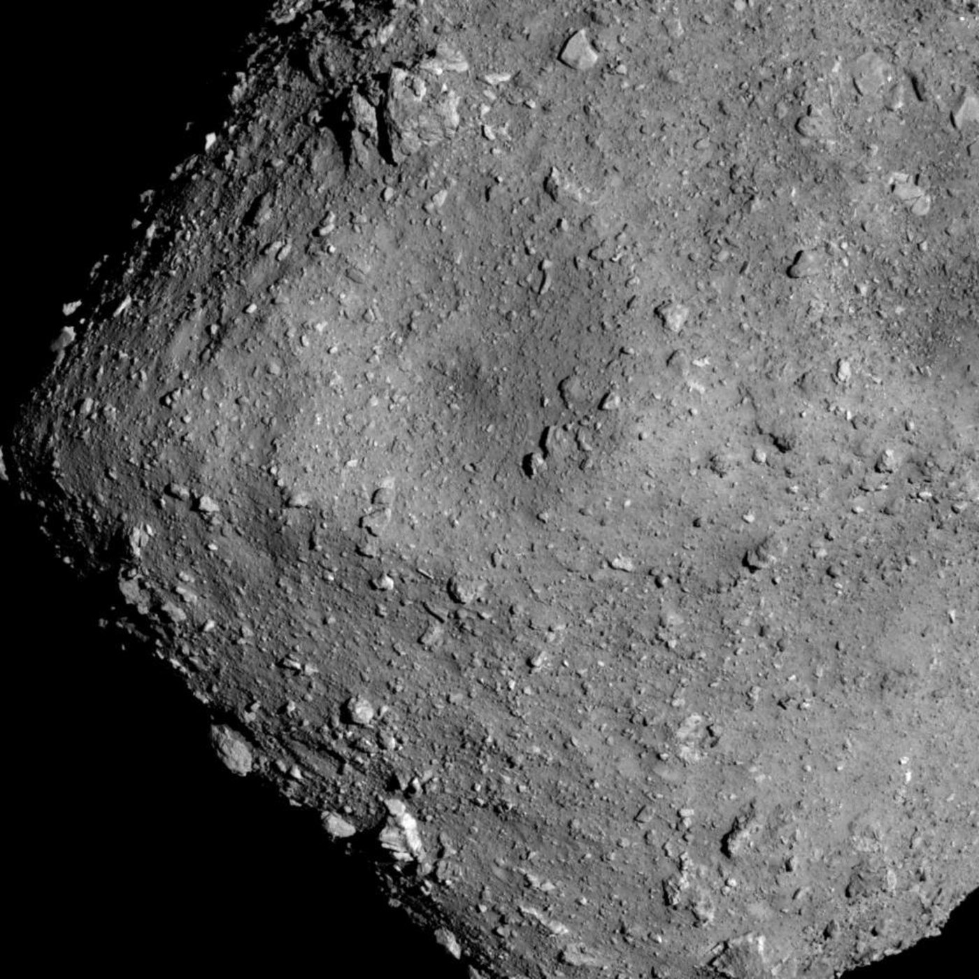 Rotsblokken en krater op asteroide Ryugu