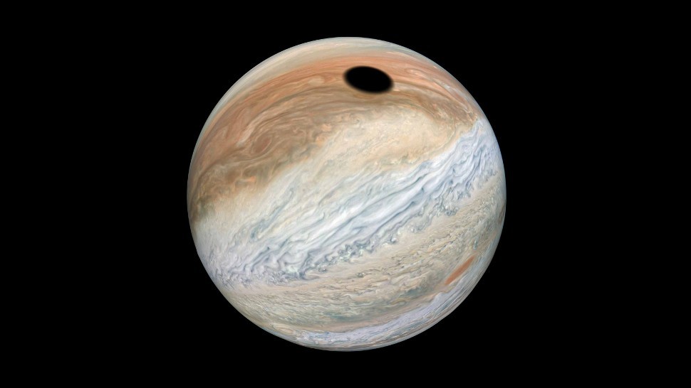 De schaduw van de maan Io valt op Jupiter