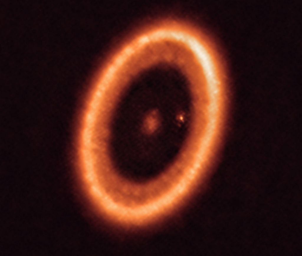 Deze ALMA-opname toont het PDS 70 systeem. Het systeem bestaat uit een ster in het centrum en minstens twee planeten die om de ster draaien: PDS 70b (niet zichtbaar op deze opname) en PDS 70c. deze laatste wordt omringd door een circumplanetaire schijf (de punt rechts van de ster)