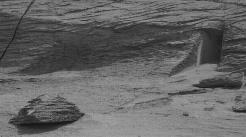 Foto van de Curiosity rover die iets toont dat lijkt op een deuropening op Mars.