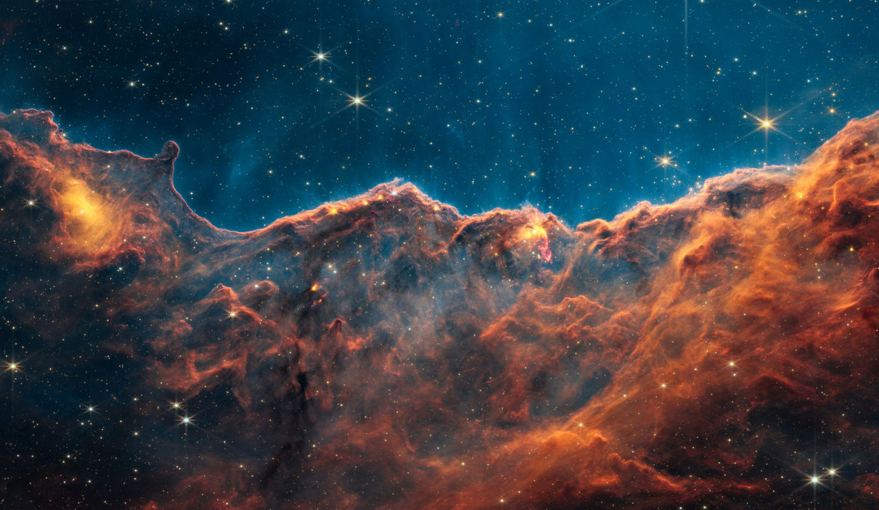 Deze Webb-opname toont de Kosmische Kliffen, een gebied aan de rand van een gigantische gasvormige holte in NGC 3324. 