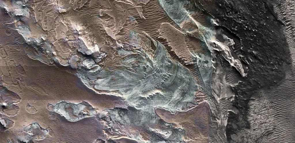 Een foto van het landschap van Mars van bovenaf waarop ijsafzettingen te zien zijn.