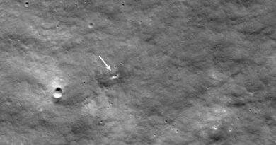 een kleine krater op het grijze oppervlak van de maan.