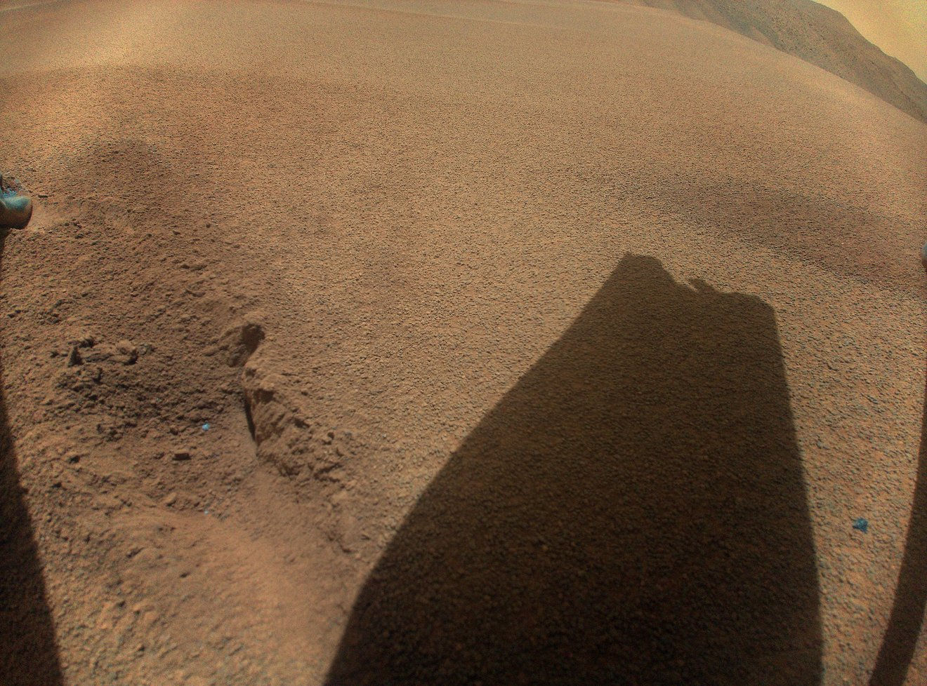 Een schaduw van een kapotte helikopterrotor op Mars. 